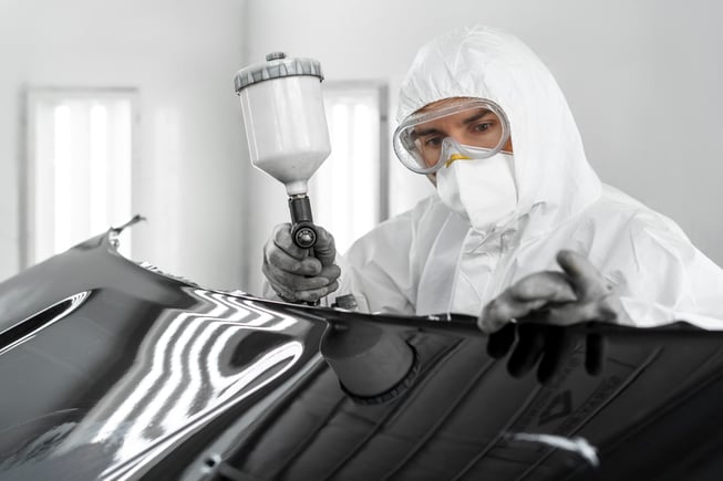 pittore-maschio-che-usa-la-pistola-per-dipingere-l-auto-nel-negozio